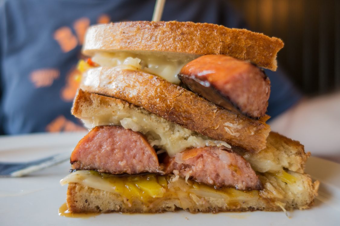 Close-up of grilled sandwich with scott pete polish sausage, cheese and sauerkraut